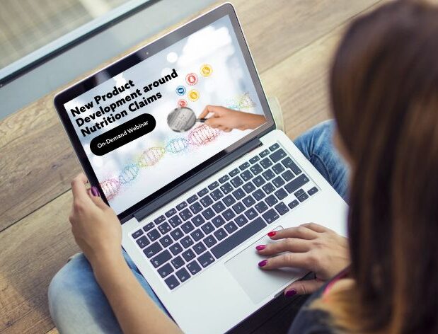 Woman sitting on wooden ground with laptop in lap. Screen shows white background with words, 